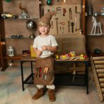 niño duendecillo arreglando juguetes en taller navideño de Valencia