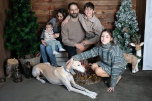 Familia completa con su perro en el decorado navideño de Mar Atienza Fotografía en Valencia.