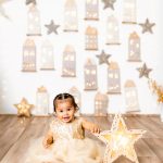 Bebé sonriente con una estrella iluminada en el Pueblo Secreto de la Navidad