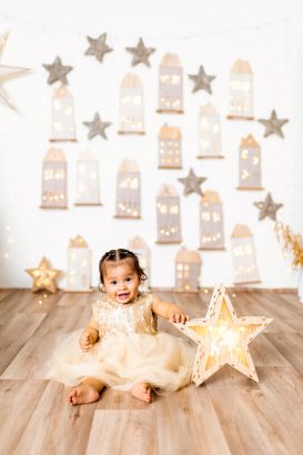 Bebé sonriente con una estrella iluminada en el Pueblo Secreto de la Navidad