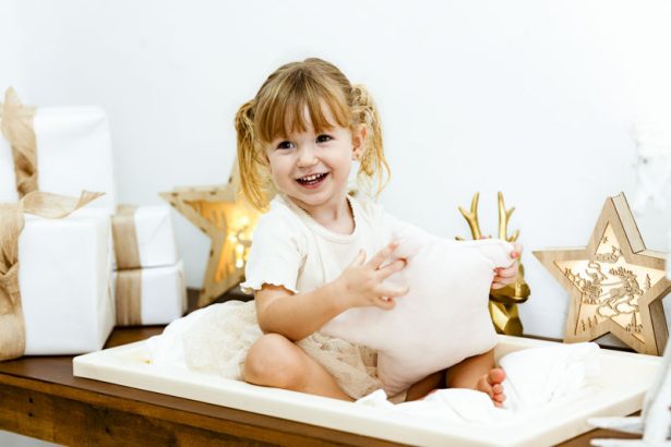 Niña pequeña jugando con un cojín en un escenario de Navidad en Valencia