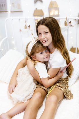 Dos hermanas abrazadas durante una sesión de fotos de Navidad en Valencia