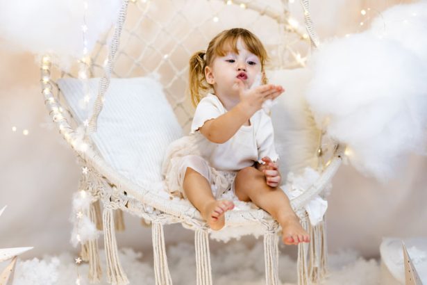 Niña soplando nieve desde un columpio durante una sesión de Navidad en Valencia